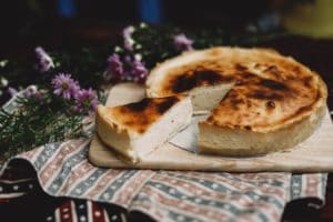 Käsekuchen, veganer Käsekuchen, Cheesecake, Kuchen auf Brett, Lieblingsrezept, Nachtisch, Süßspeise, lila Blumen